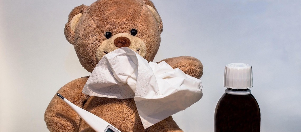 Ein bamse som tørker snue og  viser eit temometer og hostesaft