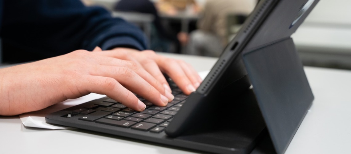 En som skriver på tastaturet til ipaden