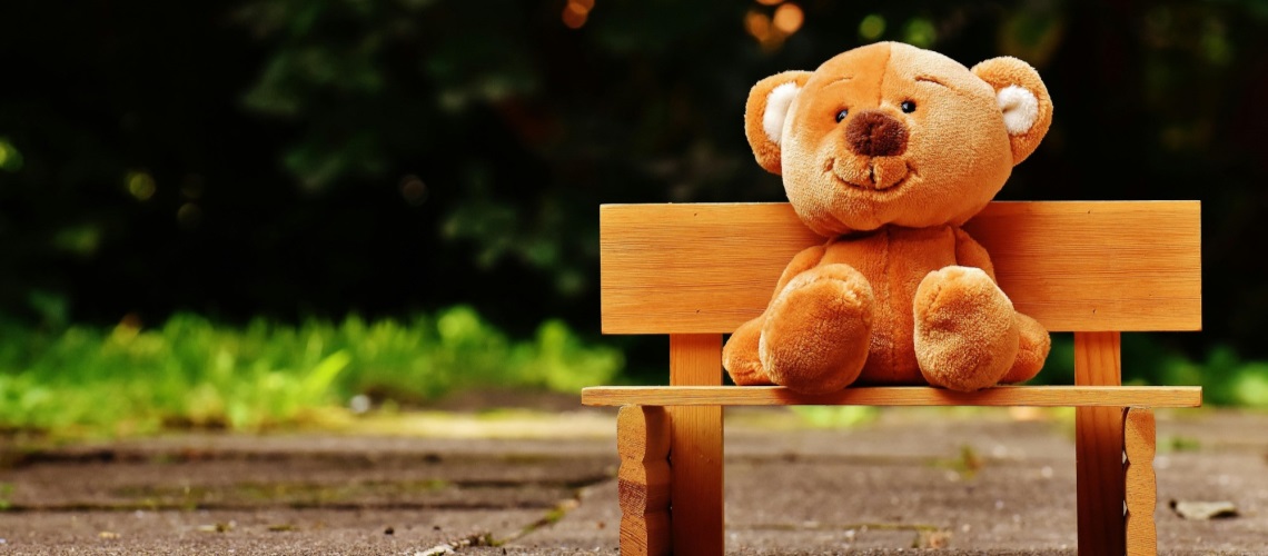 Bamse som sitter på benk